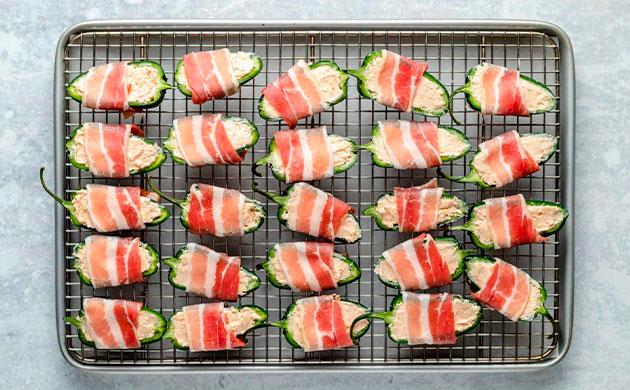 Оборачивание фаршированных перцев халапеньо ломтиками бекона